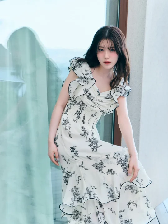 白い花柄のフリルドレスを着用した女性