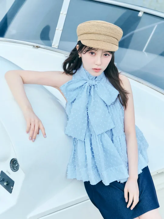 麦わら帽子と水色のフリルブラウスが夏らしい女性のポートレート