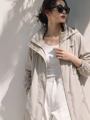 ベージュのフード付きコートを着用した女性