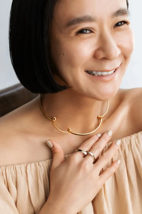 ゴールドネックレスとリングを身につけた女性の笑顔のポートレート