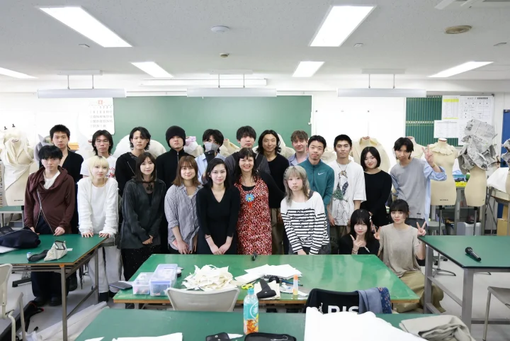 ファッションデザインの教室で集合写真を撮る生徒たち