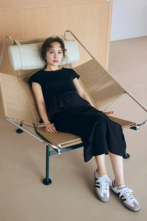現代的なデザインの椅子に座る若い女性