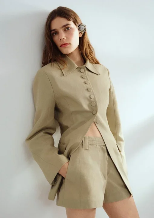 ベージュのジャケットとショートパンツのセットアップの女性