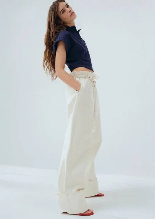 ネイビーのクロップドトップスとワイドパンツの女性