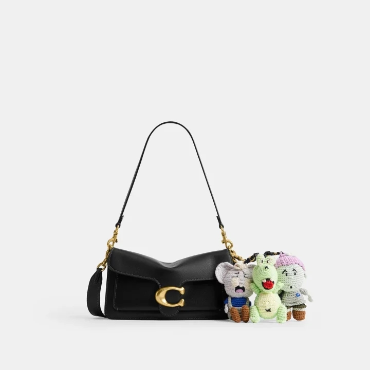 黒いレザーのショルダーバッグと編みぐるみチャーム