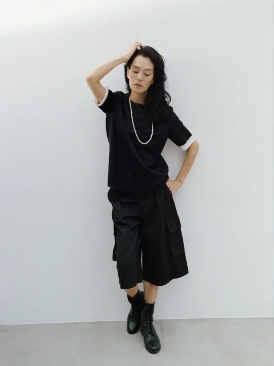 パールネックレスとショートパンツの女性