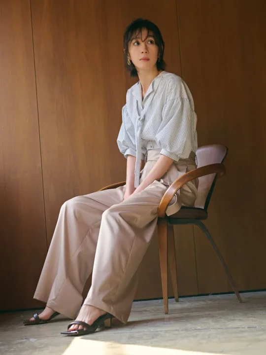ストライプのブラウスとベージュのワイドパンツを着用したポートレート