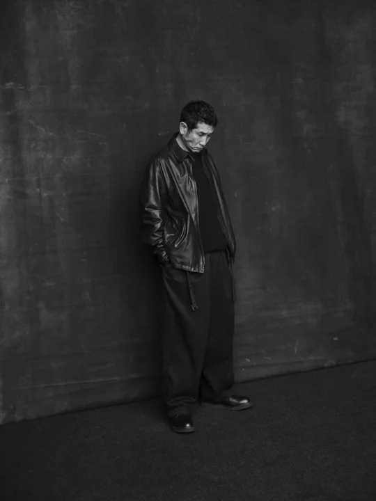 モノクロの男性全身ポートレート、レザージャケット