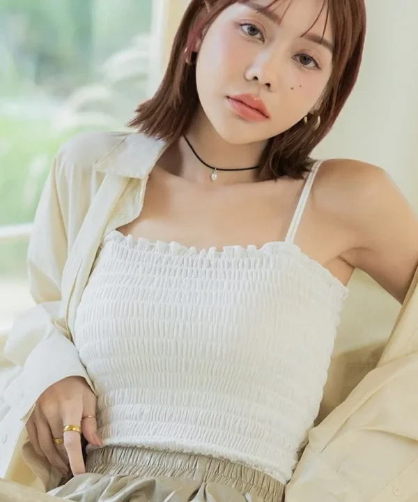 白いシャーリングトップスを着た女性