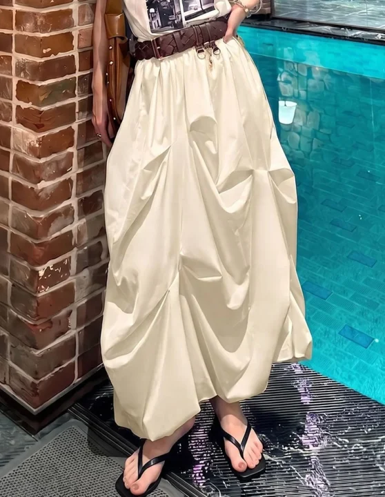 白いロングスカートとグラフィックTシャツの女性