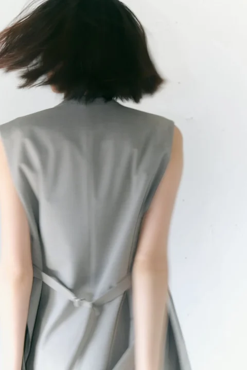グレーのノースリーブトップスを着用した女性の後ろ姿