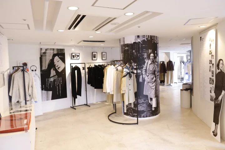 アパレルショップの店内で、向田邦子とUNCRAVEのコラボレーションを示すポスターが飾られた展示風景