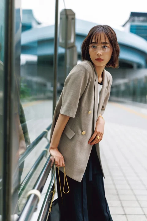都会的な背景の屋外で手すりに寄りかかる女性