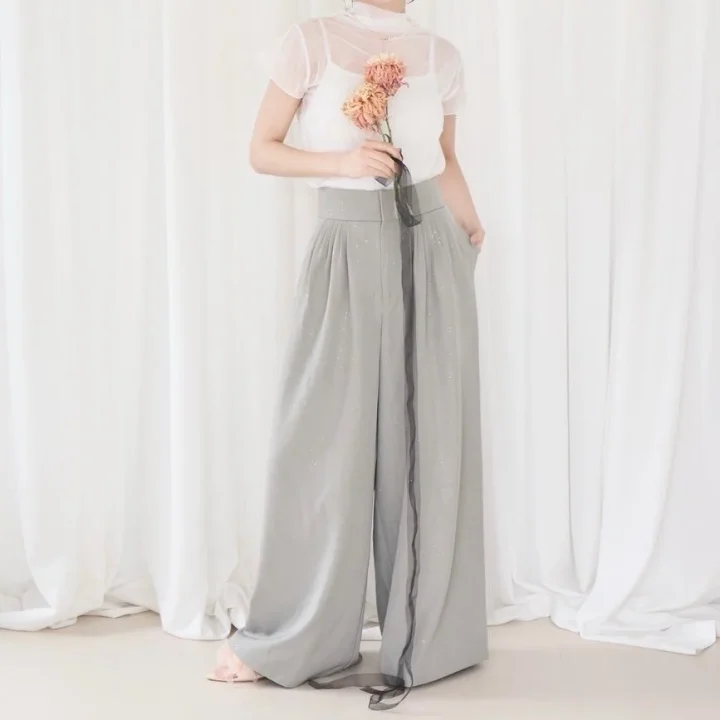 グリッターハイウエストパンツを着用した女性