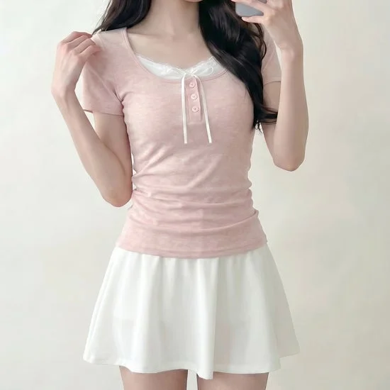 ピンクの半袖Tシャツと白いミニスカートを着用したコーディネート