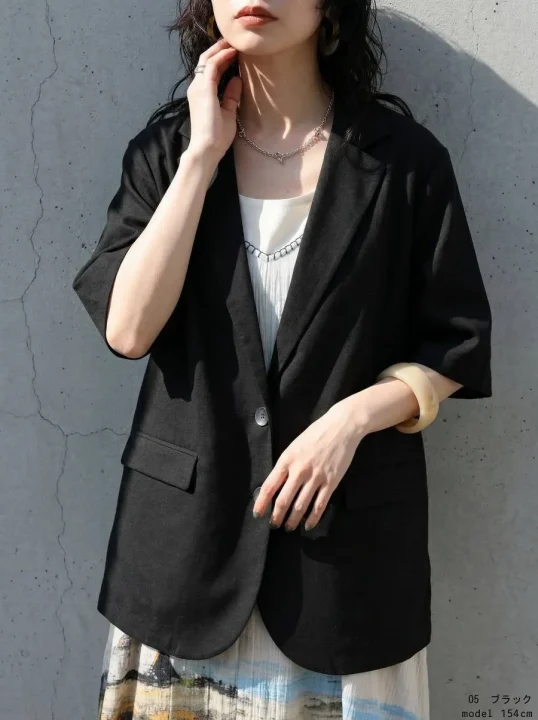 黒の半袖ジャケットと柄スカートを着用した女性