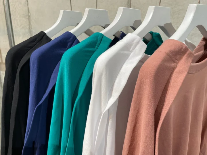 カラフルな長袖Tシャツがハンガーにかけられ並べられている様子
