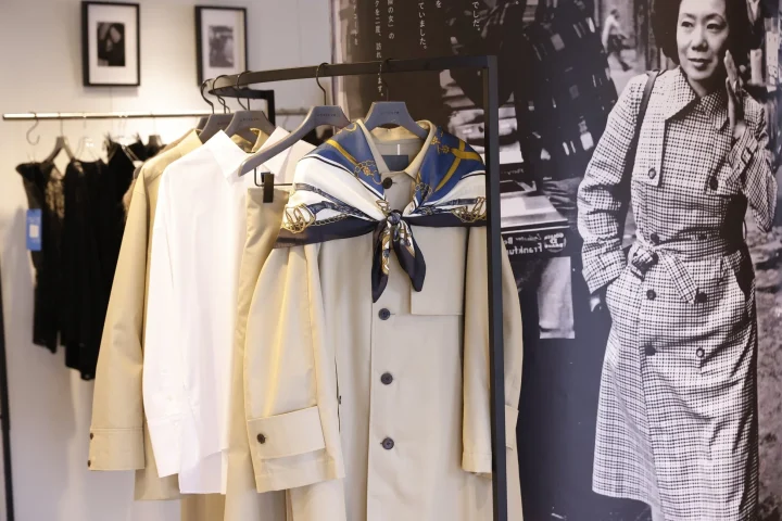 アパレルショップの店内で、ベージュのトレンチコートとスカーフがコーディネートされたディスプレイ