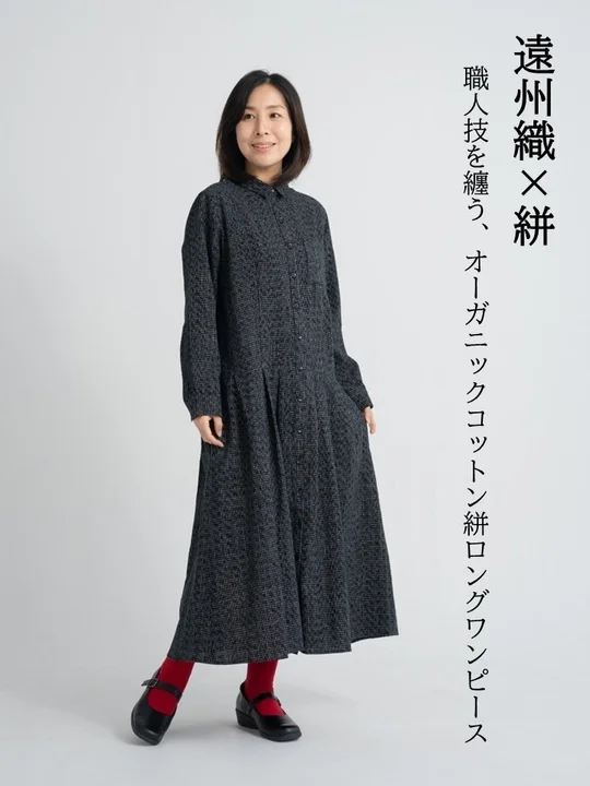 遠州織と絣を組み合わせたオーガニックコットン製のロングワンピースを着用した女性の全身像
