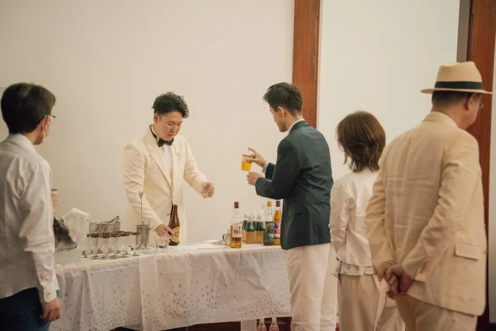 タキシードを着た男性が飲み物を提供するパーティー会場