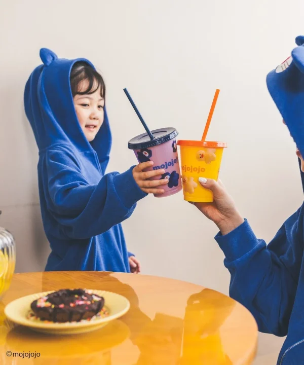 ストロー付きのカラフルなカップを乾杯する親子