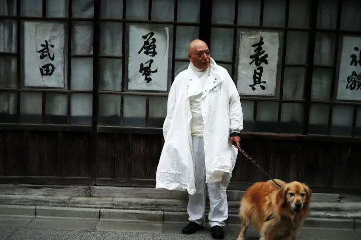 男性と犬、日本家屋