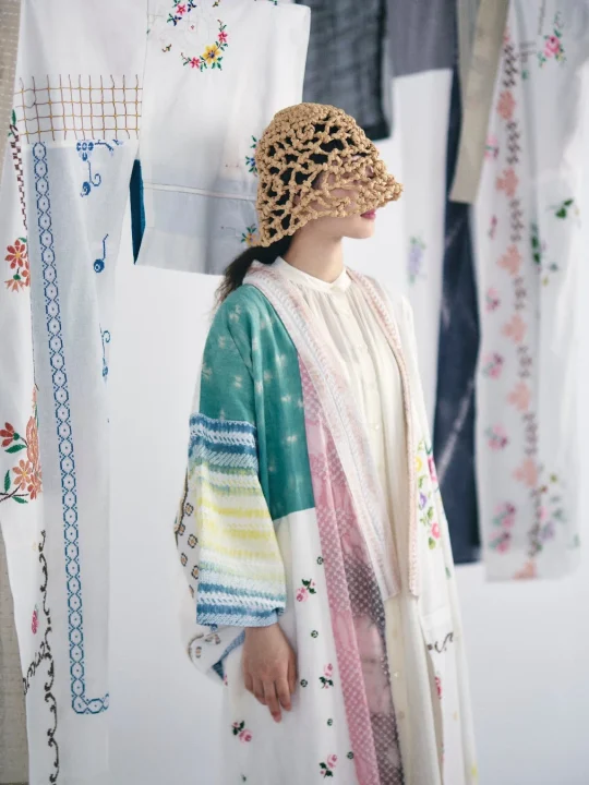 編み目の帽子と刺繍・パッチワークローブの女性