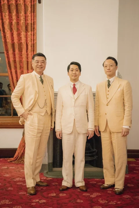 淡い色のフォーマルなスーツを着た男性3人の集合写真