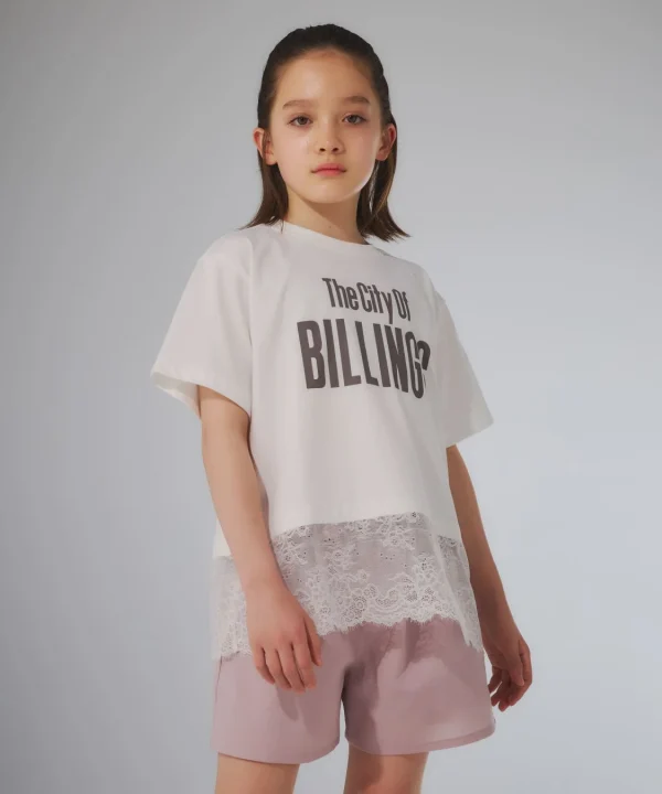 白いTシャツとピンクのショートパンツを着用した少女がポーズをとっています。Tシャツの裾にはレースがあしらわれており、カジュアルながらも可愛らしい印象です。