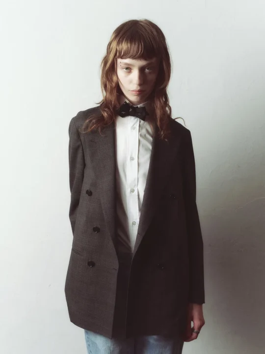 グレーのジャケットと蝶ネクタイを着用した人物のポートレート