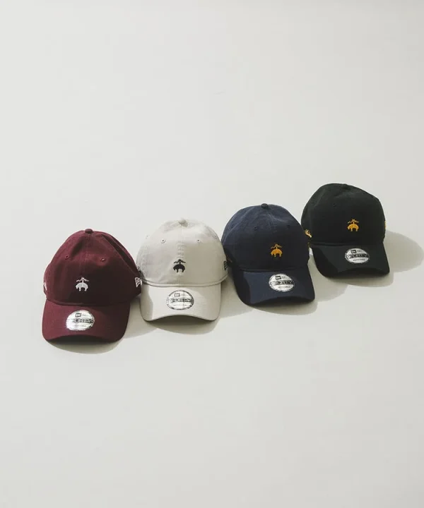 白背景に4つのNew Era 9FORTYキャップが並べられています。マルーン、ベージュ、ネイビー、ブラックの異なる色のキャップがあり、それぞれに動物のロゴが刺繍されています。