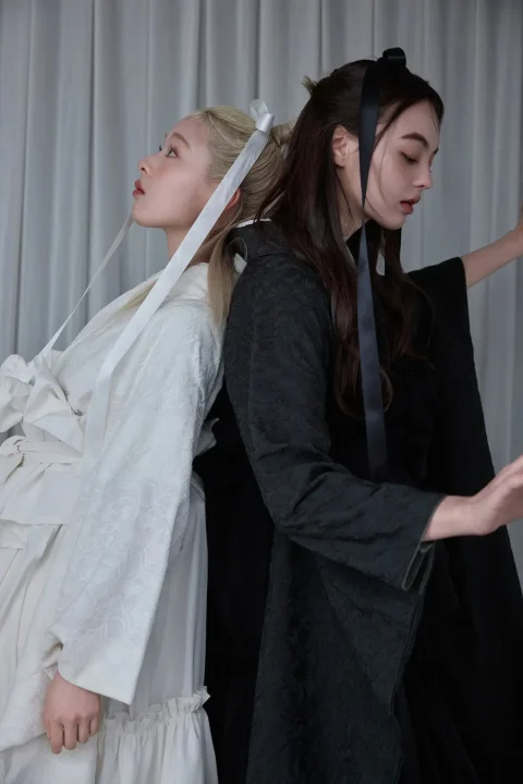 白と黒の服の女性2人
