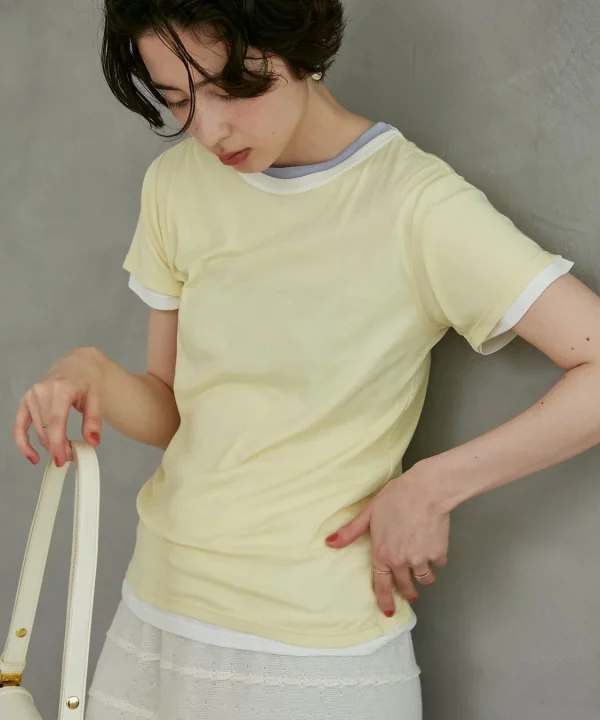 淡い黄色のTシャツと白いスカートを着用した女性