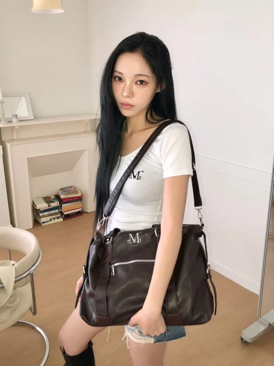 ダークブラウンのショルダーバッグを持つ女性