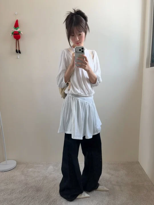白いトップスと黒いワイドパンツ