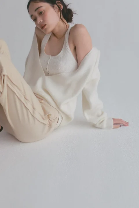 オフホワイトとベージュのカジュアルな服装の女性