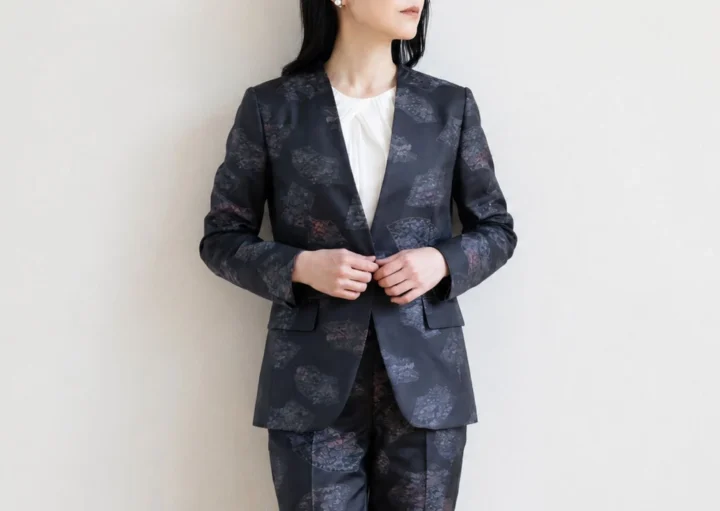女性がスーツを着て立つ画像
