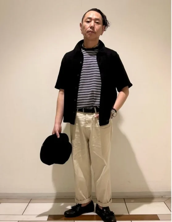 黒の半袖シャツにボーダーTシャツ、ベージュのパンツを合わせたカジュアルなスタイル