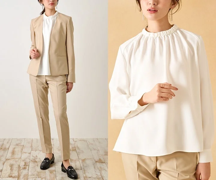 ベージュのノーカラージャケットとパンツのセットアップを着用した女性