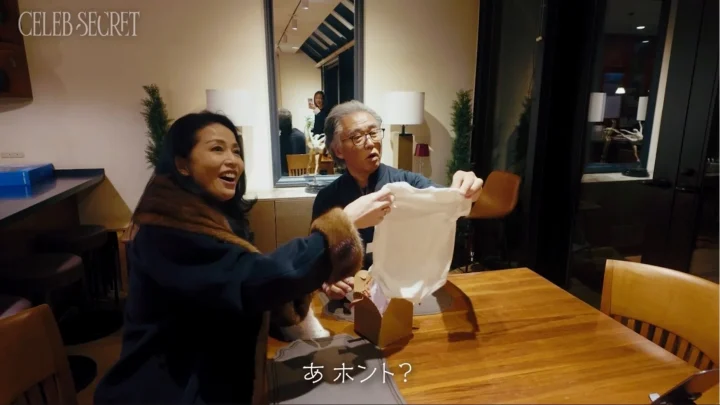 ベビー服のプレゼントに喜ぶ父親とパートナー