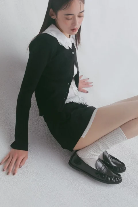 黒カーディガンとショートパンツの女性