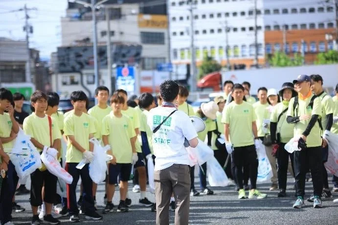 黄緑色のTシャツを着て清掃活動に参加する人々