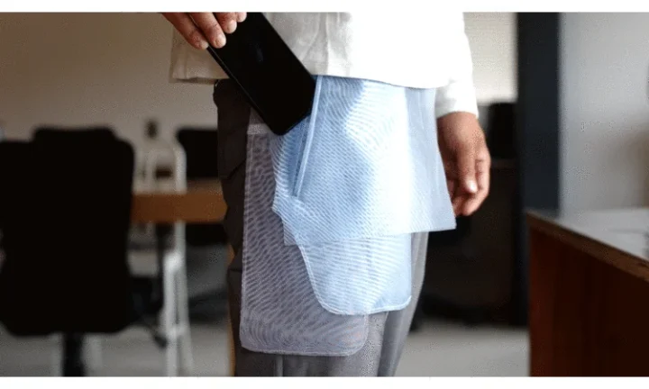 スマートフォンを衣服のポケットに入れる様子