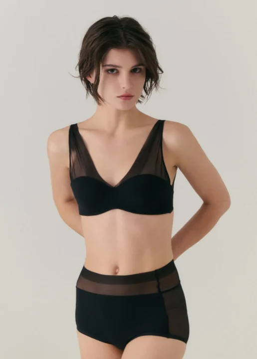 黒いメッシュブラレットとハイウエストショーツを着用した女性