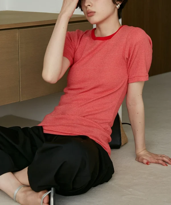 赤いストライプのTシャツと黒いパンツを着用した女性