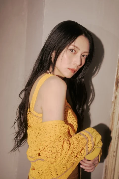 黄色いニットの女性