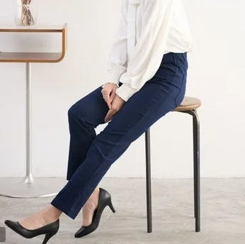 白いブラウスとネイビーのパンツを着用した女性