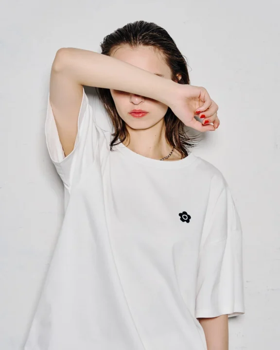 白のロゴTシャツを着用した女性