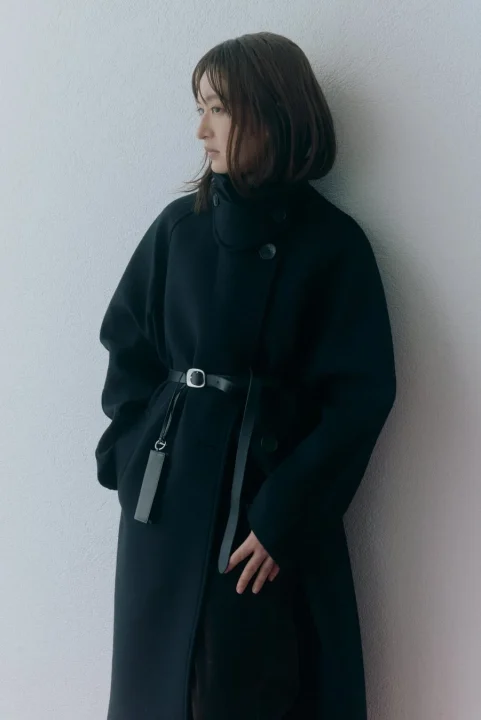 黒いロングコートを着用した女性