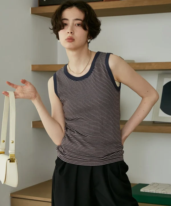 ストライプのタンクトップと黒いパンツを合わせた女性
